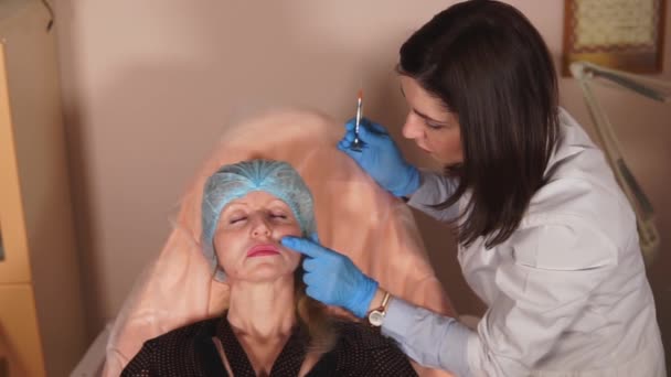 De schoonheidsspecialist-arts controleert hoe de fillers heeft — Stockvideo