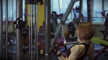Yetişkin bir kadın vücudu üzerinde spor simülatörü egzersiz öncesine kneads.