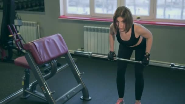 L'athlète soulève la barre dans une position semi-courbée pour le développement des muscles — Video