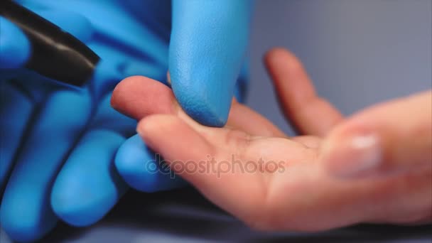 Arts met behulp van lancet op vrouwtjes patiënt vinger. Druppel bloed op vinger. — Stockvideo