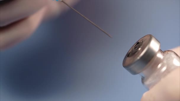 The syringe piercing the lid of the ampoule — Stock Video