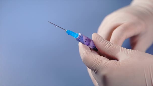 Syringe in artsen handen. Geneeskunde lekken uit een spuit. — Stockvideo
