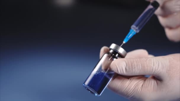 Mixing of medicine. Doctor squirting with syringe into ampoule of medicines — Stock Video