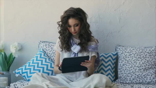 Junge Frau druckt Nachricht in sozialem Netzwerk auf Tablet im Schlafzimmer aus. — Stockvideo
