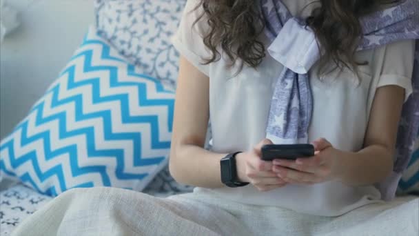 Primo piano colpo di una mano femminile con un orologio intelligente che conversano su uno smartphone . — Video Stock