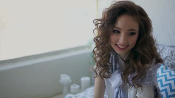 Крупним планом знімок молодої жінки, яка посміхається під час прослуховування музики в плеєрі — стокове відео