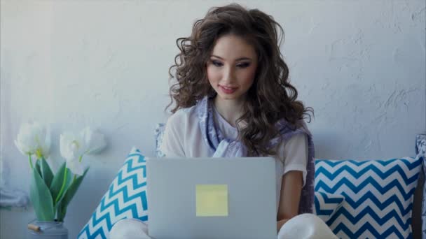 Μια νεαρή γυναίκα, κουβεντιάζοντας με τους φίλους στο διαδίκτυο σε έναν φορητό υπολογιστή — Αρχείο Βίντεο