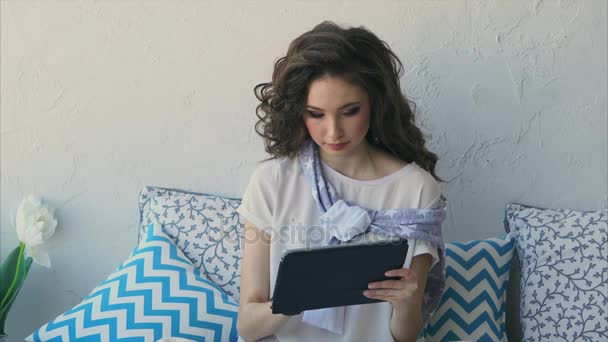 Mujer joven imprime un mensaje en la red social en una tableta en el dormitorio . — Vídeos de Stock