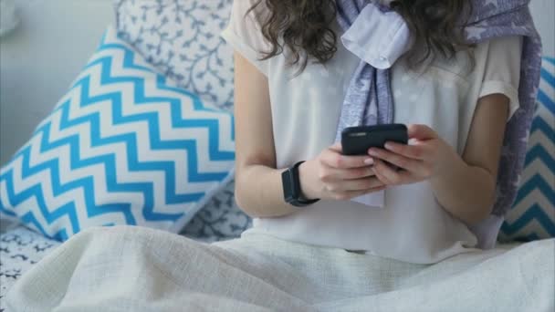 Primo piano colpo di una donna mani con un orologio intelligente che chatta su uno smartphone — Video Stock