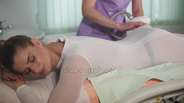 Женщина в косметологе. Доктор использует оборудование для вакуумного массажа сжиженного нефтяного газа на теле — стоковое видео