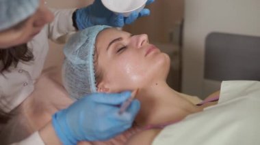 Bayan hasta üzerinde yüz maskesi uygulayarak güzellik uzmanı. Kozmetik gençleştirmek.