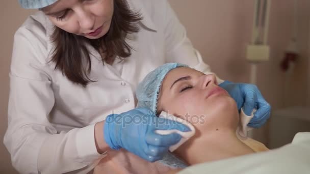 Paciente femenina recibiendo mascarilla facial en salón de belleza de spa . — Vídeos de Stock