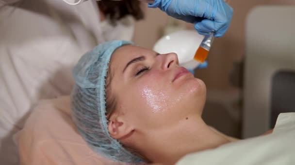 Una donna in un centro benessere con maschera facciale. Salone di bellezza. Ringiovanire la cosmetologia . — Video Stock