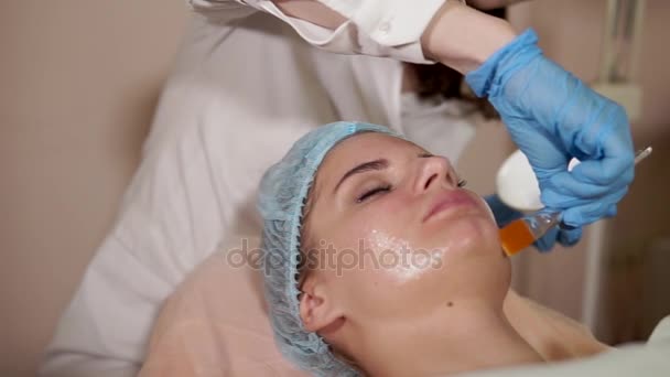 Διαδικασία κοσμετολογία. Γυναίκα να πάρει προσώπου μάσκα εφαρμόζεται από cosmetologist. — Αρχείο Βίντεο