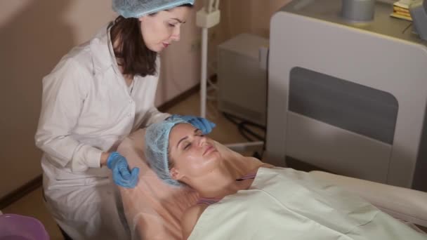 Paziente femminile ottenere maschera facciale nel salone di bellezza spa — Video Stock