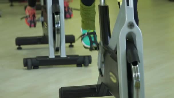 Nära upp skott av fötterna på idrottare som är upptagen på en motionscykel. — Stockvideo