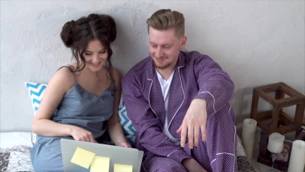 Paar kijken naar video's samen op laptop in bed — Stockvideo