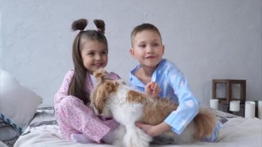 Küçük kız ve erkek köpek yatakta ile sarılma. Mutlu çocukluk.