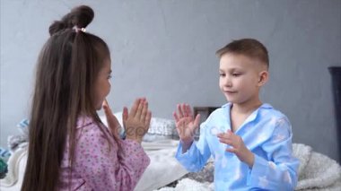 Küçük kız ve erkek ev yapımı pijama giymiş kardeşim ellerine oyunu oyun.