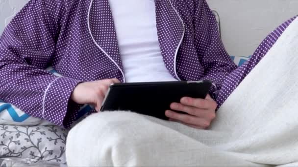 Homem com tablet na cama. Tecnologia sem fio na Internet na vida cotidiana . — Vídeo de Stock