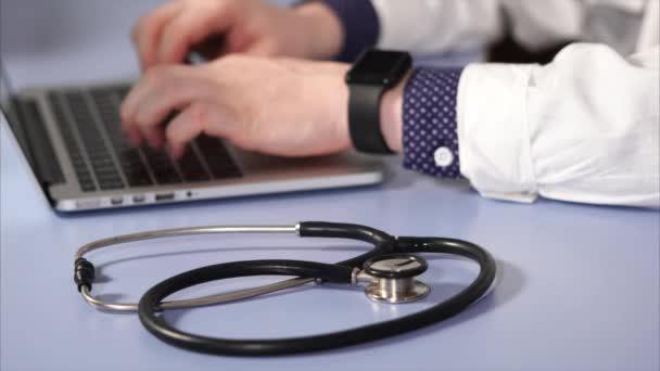 Detailní záběr záběr stetoskop, který leží vedle do rukou lékařů — Stock video