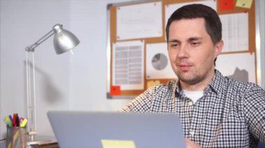 Genç bir adam ailesine bir video ve Internet kullanarak laptopda konuşuyor