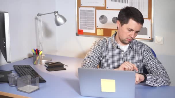 Il capo dell'impresa edile controlla l'e-mail sull'orologio intelligente dietro il suo posto di lavoro — Video Stock