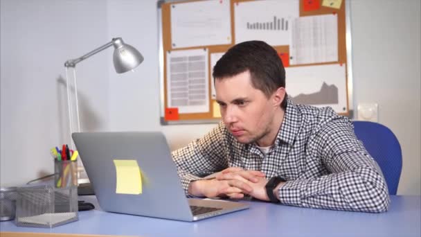 Um homem que olha no laptop é surpreendido pelo que está acontecendo na Internet — Vídeo de Stock