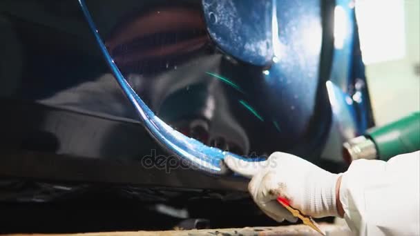 Zaměstnance garáž zahřívá fénem kontinuální povrchu vinylová fólie. — Stock video