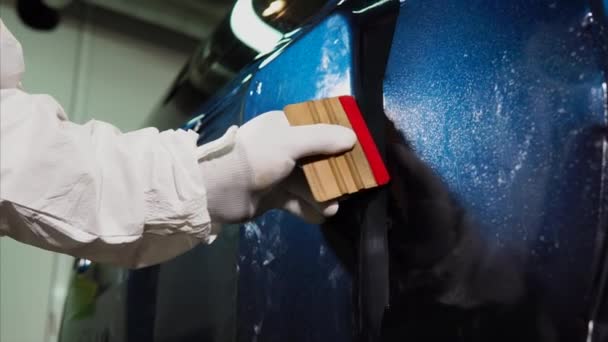 Deskundigen op het gebied van het gladde oppervlak van de garage van de machine, geplakte vinyl. — Stockvideo