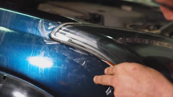 Nära upp skott av master skärande vinyl film av speciell kniv på den blå bilen. — Stockvideo
