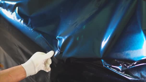 Close-up shot van de handen van de meesters in het tankstation vinyl op de machine gezet. — Stockvideo