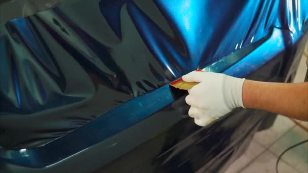 Close-up shot van mans handen verwijdert luchtbellen terwijl tuning auto — Stockvideo