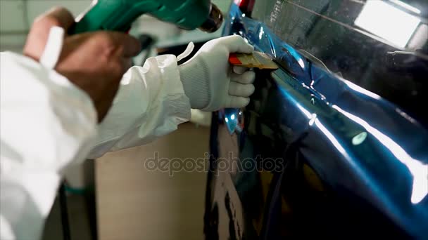 Close up tiro de homem aplicando filme de vinil enquanto tuning carro — Vídeo de Stock