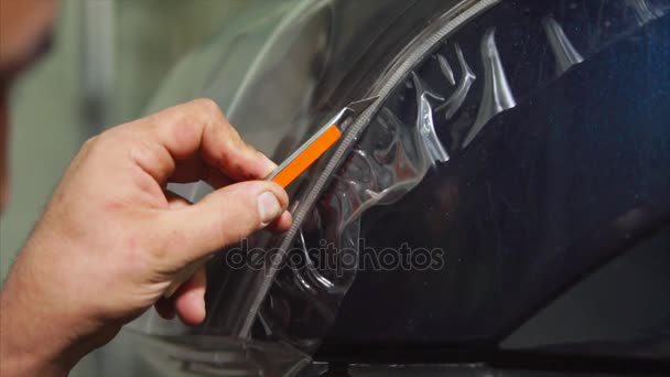 Nära upp skott av master skärande vinyl film av speciell kniv på den blå bilen. — Stockvideo