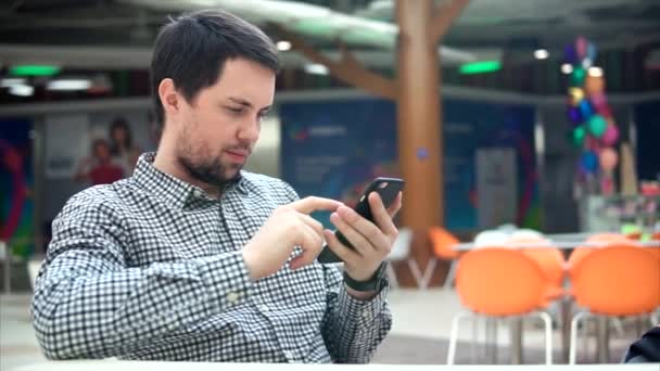 Homem caucasiano com smartphone na cafetaria . — Vídeo de Stock