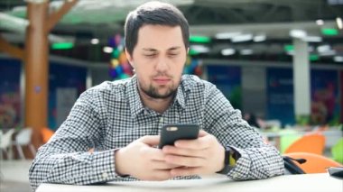 Bir akıllı telefon ve akıllı bir saat yemek alanında genç bir adam görünüyor