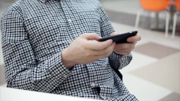 Vista de cerca del hombre jugando en el teléfono inteligente en la cafetería . — Vídeo de stock