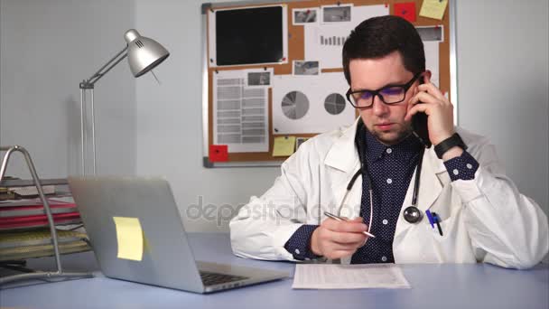 Дорослий лікар розмовляє з пацієнтом по телефону, щоб створити свій анамнез — стокове відео