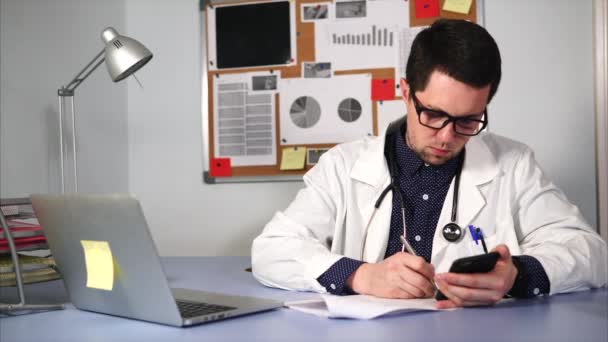 Serious doctor makes patients analysis in the form that is stored in the phone — Stock Video