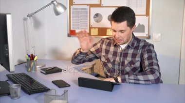 Bir adam arkadaşına tablet üzerinde çalışma molası sırasında konuşuyor