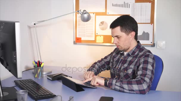 Γραφείο εργαζόμενος πληκτρολογώντας στο tablet και σκέψης. — Αρχείο Βίντεο