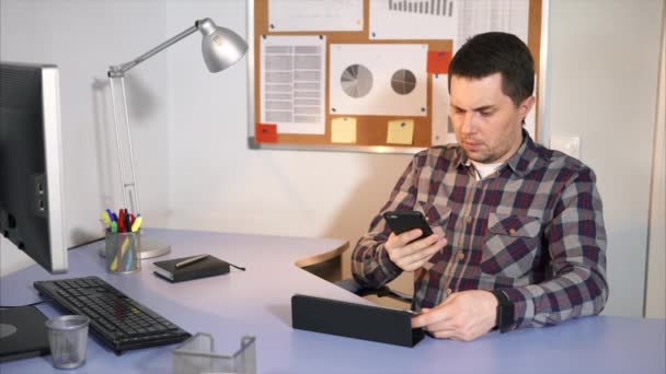 Jonge zakenman werk in zijn kantoor met zijn tablet — Stockvideo