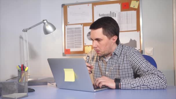 男子抽电子香烟，办公室工人雾在键盘上键入文本时. — 图库视频影像