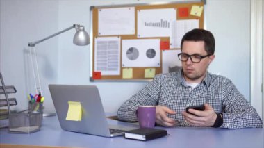 Oturma ve smartphone kullanarak ofis çalışanı. Bir ara ve içecek kahve götürdü.