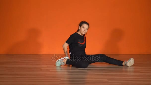 Een jong meisje danst een lagere breakdance met behulp van het hele lichaam voor bewegingen — Stockvideo