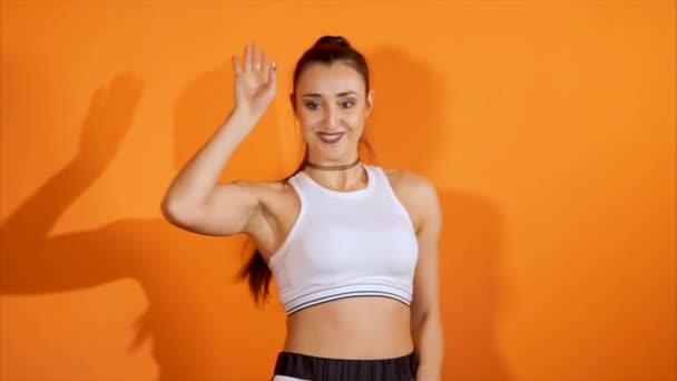 若い女性は流行ダンス中に彼女の手でプラスチックのポーズを示しています — ストック動画