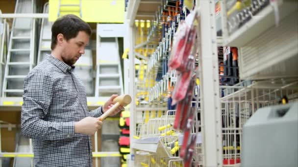 Man choosing wooden hammer in hardware store. — Stock Video