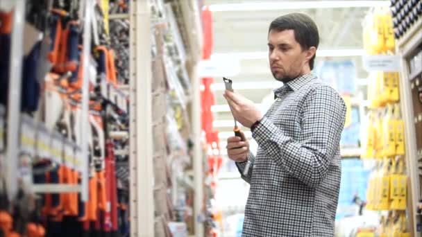 Adulte choisit un tournevis dans le département des matériaux de construction dans le centre commercial — Video