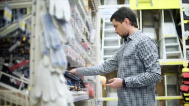 Donanım mağaza alışveriş. Adamın yanına raf araçları ve aletleri